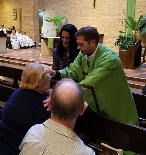 Fr. Bart anoints a woman at last year's anointing Mass.